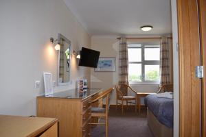 a hotel room with a desk and a bed and a table at The Little Haven Hotel On The Beach in South Shields