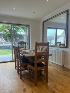 a dining room with a wooden table and chairs at Bungalow with hot tub & Sauna in Kingsgate