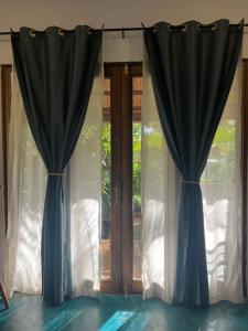 two blue curtains in front of a window at Siri Beach Lodge in Nungwi