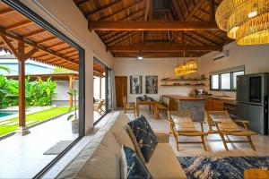 an open kitchen and living room with a couch and chairs at Luxury 2 Bedroom Tropical Villa in Jimbaran