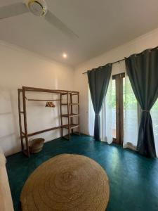 a room with a bed and a table and curtains at Siri Beach Lodge in Nungwi
