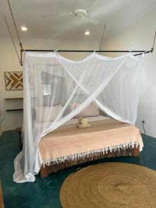 a bed with a mosquito net in a room at Siri Beach Lodge in Nungwi
