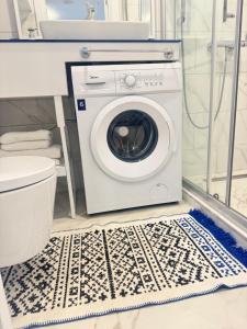 a washing machine in a bathroom next to a toilet at EVIS LTD apartments Batumi 2 in Angisa +7 photos
