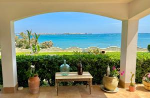 a patio with vases and a table with a view of the ocean at Villa Incanto on the Sea in Syracuse