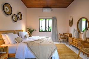 a bedroom with a bed and a desk and a mirror at Luxury 2 Bedroom Tropical Villa in Jimbaran
