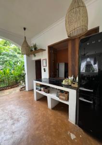 a kitchen with a counter and a black refrigerator at Siri Beach Lodge in Nungwi