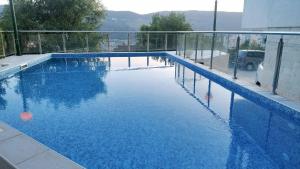 a swimming pool with blue water in a building at Topla Heat Apartman in Herceg-Novi