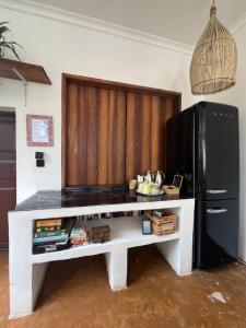 a kitchen with a white table and a black refrigerator at Siri Beach Lodge in Nungwi