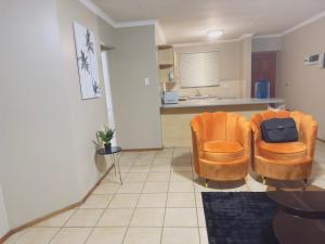 ウィットバンクにあるLuxury two bedrooms apartment in Witbank overnight accommodationの椅子2脚とテーブルのあるリビングルーム
