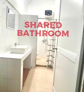 a bathroom with a sink and a shower with the words shared bathroom at Radish Cathedral Homestay in Hanoi