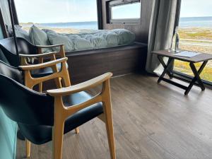 a room with two chairs and a bed and a table at Atlantic Road Sleeping Experience Re-Treats in Vevang +16 photos