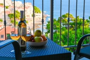 a table with a bowl of fruit and two glasses of wine at B&B Zora Panoramic View in Milna