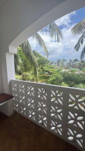 a balcony with a view of a palm tree at Siri Beach Lodge in Nungwi