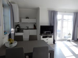 cocina y sala de estar con mesa y TV en Refugium im Brook Timmendorfer Strand, en Timmendorfer Strand