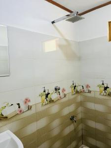 NikawatawanaにあるBloom house homestayの洗面台と人形が置かれた棚のあるバスルーム