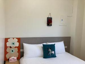 uma cama com um travesseiro azul em cima em 幸運草輕旅 em Jiaoxi