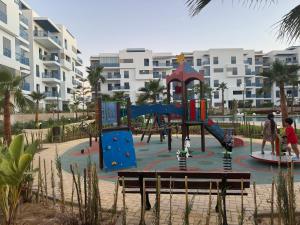Un parque infantil en un complejo turístico con gente jugando en él. en Rincón del Mar, en Martil