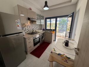 Una cocina con un refrigerador y una mesa dentro. en Rincón del Mar, en Martil