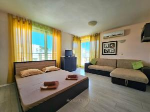 a living room with a bed and a couch at Aпартаменти Хоризонт in Sozopol +66 photos