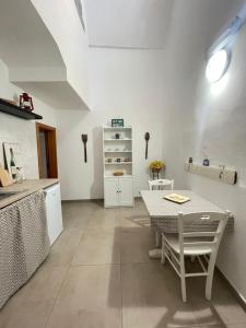a kitchen with a table and a table and a counter at Casa Buena Vida (locazione ad uso turistico) in Monopoli