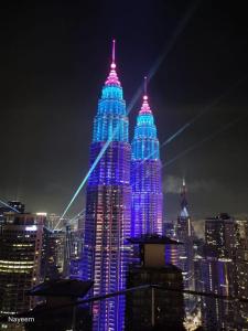 a large building is lit up in blue and purple at STAR KLCC By Comfort Hospitality in Kuala Lumpur