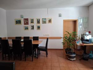a dining room with a table and black chairs at Pensiunea Paloma 3 stele Brasov in Braşov