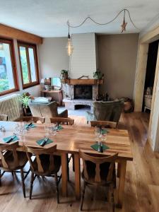 a dining room with a wooden table and a fireplace at Le Bellacha in La Léchère +34 photos
