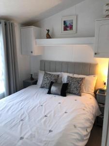 a bedroom with a large white bed with pillows at Dunes Views in Prestatyn