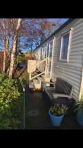 a house with a porch and a couch and a flower pot at Dunes Views in Prestatyn