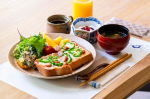 un piatto di cibo con un panino e un'insalata di 温泉御宿 るりびたき a Matsumoto