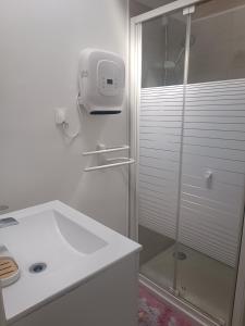 une salle de bain blanche avec une douche et un lavabo dans l'établissement Maisonnette dans hameau provençal, à Cabriès