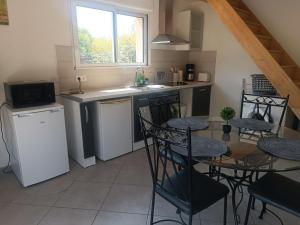 une cuisine avec une table, des chaises et un évier dans l'établissement Maisonnette dans hameau provençal, à Cabriès