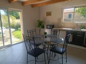 une cuisine avec une table et des chaises dans une cuisine dans l'établissement Maisonnette dans hameau provençal, à Cabriès