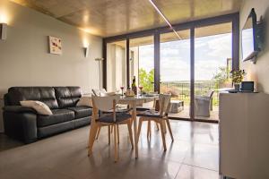 Una sala de estar con una mesa y sillas y un sofá. en Gîte Mas Palat, en Gignac