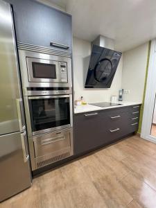 a kitchen with a stainless steel refrigerator and a microwave at Casa Orquídea in Platja d'Aro
