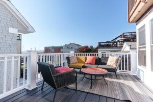 a balcony with chairs and a table on a deck at CHIC Thames Harbor free parking in Newport