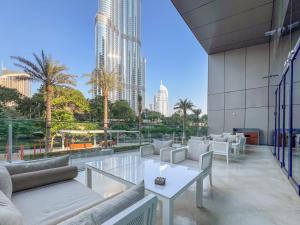 a balcony with couches and tables on a building at The Address Residences Dubai Opera - Luxury 3BR Stay with Stunning Burj Khalifa & Fountain Views in Dubai
