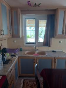 a kitchen with two sinks and a window at Maria apartment in Marathéa