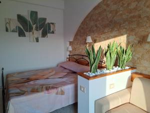 a bedroom with a bed and two potted plants at Casa La Graziosa Soverato in Soverato Marina