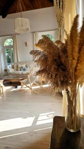 een vaas met gedroogde bloemen op een tafel in de woonkamer bij Maison Essentielle in Tournon-sur-Rhône
