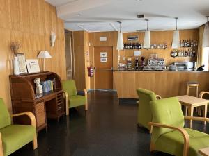a waiting room with green chairs and a counter at Hotel España in Guadalajara