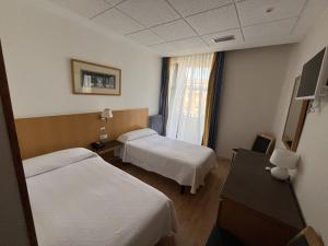 a hospital room with two beds and a window at Hotel España in Guadalajara
