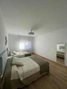 a bedroom with two beds and a mirror at Chalet Avenida El Barraco Avila in El Barraco +14 photos