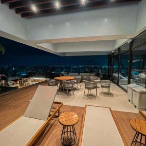 a restaurant with tables and chairs and a view of the city at Studio Beira-mar, rooftop com piscina e jacuzzi in Fortaleza
