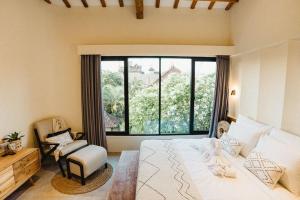 a bedroom with a bed and a large window at Villa KHAYA Seminyak Stylish 2-Bedroom Villa Just 900m from the Beach in Badung +71 photos