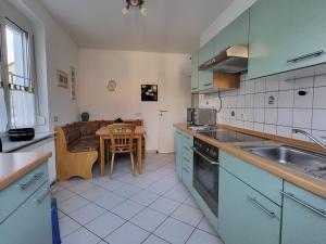 a kitchen with blue cabinets and a table with a dining room at Bodensee Idylle in Friedrichshafen