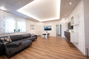 un soggiorno con un divano nero e una cucina di Ring48 City Living - modernes Wohnen mit Wohlfühlambiente mitten im Stadtzentrum - vollausgestattete Küche, Bad mit Duschbadewanne, Parkplatz a Bayreuth