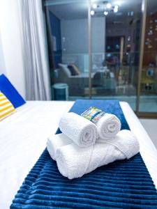 a pile of towels sitting on top of a bed at Studio Beira-mar, rooftop com piscina e jacuzzi in Fortaleza