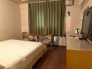 a hotel room with a bed and a desk and a table at Jahamun Hotel in Seoul