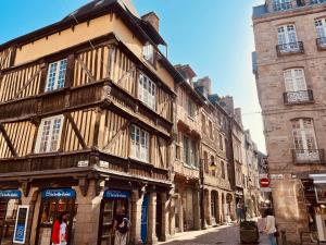 an old building on a street with people walking down it at Maison à 800m de la plage in Saint-Lunaire